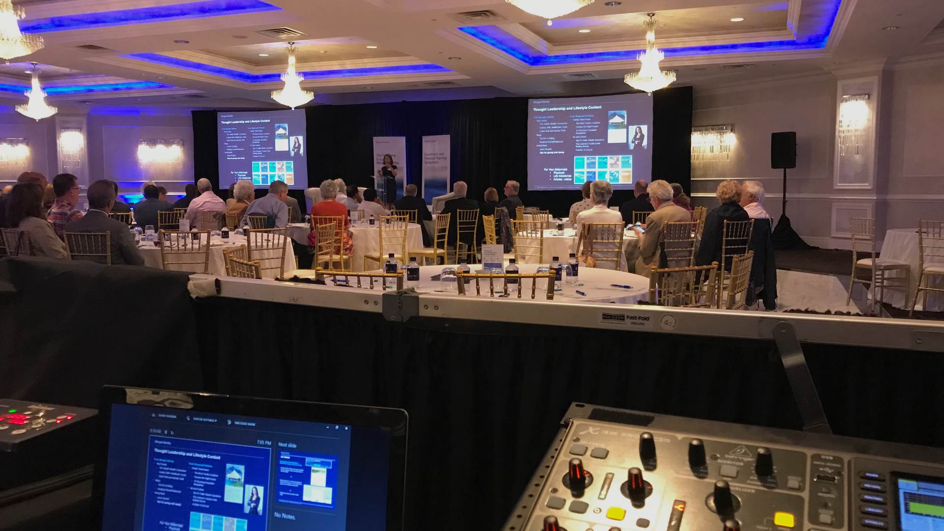Corporate AV production in Ocean County NJ ballroom — dual projection screens, mixing console, and full audience