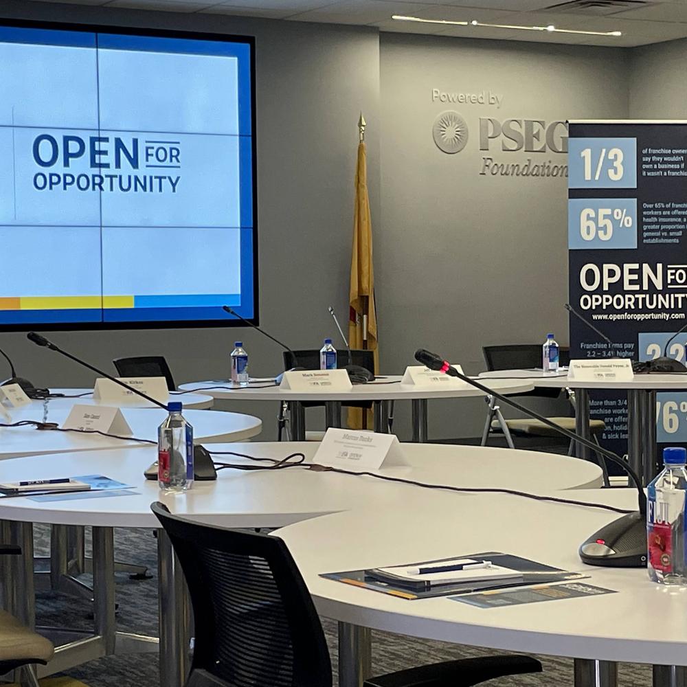 Corporate AV setup at PSEG Foundation roundtable event — gooseneck microphones, large display screen, Ocean County NJ