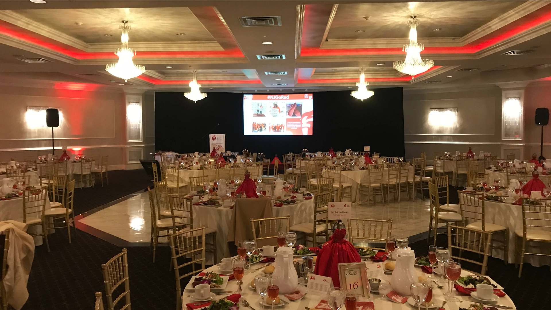 Corporate gala ballroom with LED screen stage and full dinner setup Ocean County NJ